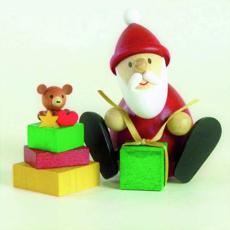 Weihnachtsmann mit Geschenk und Geschenkestapel