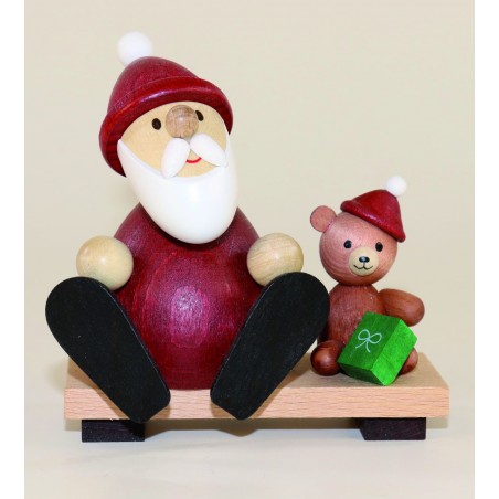 Weihnachtsmann mit Teddy auf Bank