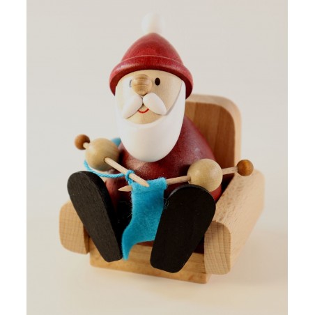 Weihnachtsmann strickend im Sessel