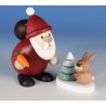 Weihnachtsmann mit Hase und verschneitem Baum